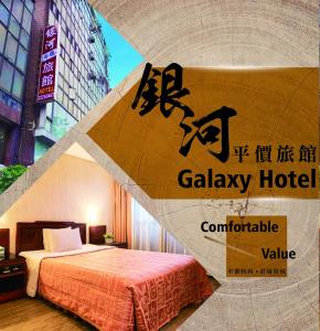 a sign for a hotel with a bed in a room at Galaxy Hotel in Taichung