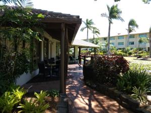 a patio at a resort with a table and chairs at Oasis Private 2 Bed Apartment in Caloundra