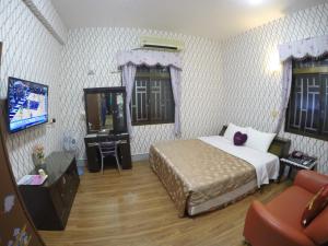 a bedroom with a bed and a television in it at Reny Lake Warm Hostel in Fanlu