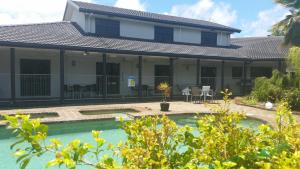 een huis met een zwembad ervoor bij Alara Motor Inn in Mackay