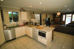 a kitchen with white cabinets and a counter top at Mount Gravatt Guesthouse in Brisbane