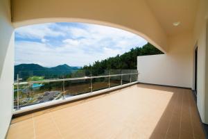 a balcony with a view of the mountains at Dongwon Youthhostel in Tongyeong