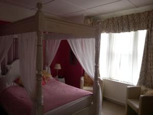 a bedroom with a canopy bed and a window at Tower House 1066 in Hastings