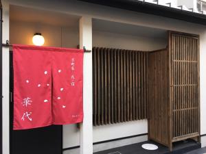 a red flag is hanging on the side of a building at Kyo-machiya Flower Inn Hanayo in Kyoto