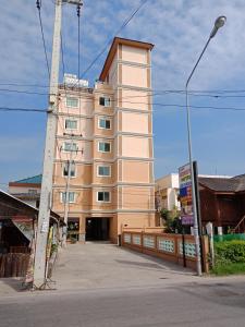 un edificio alto bronceado con una valla delante en Baanpak Sam Anong, en Hua Hin