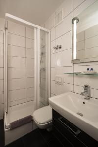 ein Bad mit einem Waschbecken, einem WC und einer Dusche in der Unterkunft Hotel Brandenburger Hof in Köln