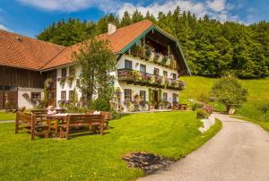 a large house with a table on the lawn at Wohlfühlbauernhof Bambichlhof in Fuschl am See