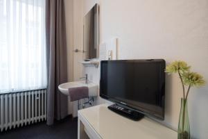 a television sitting on a table in a bathroom at Hotel Brandenburger Hof in Cologne