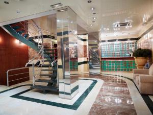 a lobby with a spiral staircase in a building at Hotel MS Maestranza Málaga in Málaga
