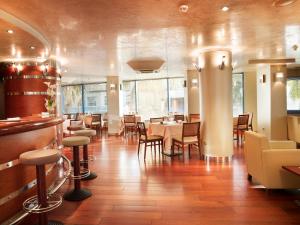 a dining room with tables and chairs and windows at Hotel MS Maestranza Málaga in Málaga