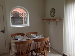 a dining room with a table with chairs and a clock at Comfortable House in Warwick in Warwick