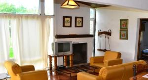 a living room with yellow chairs and a television at Chawasi Cabañas in Campo Quijano