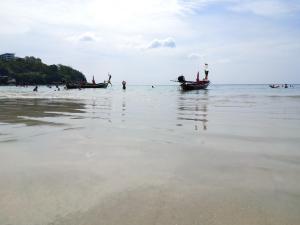 a group of people in boats on the beach at The Mantra Hotel Kata Noi in Kata Beach