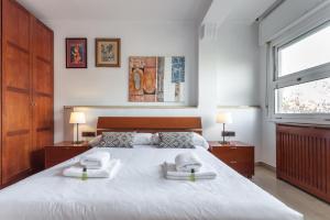 a bedroom with a large white bed with towels on it at Flateli Lepant in Barcelona