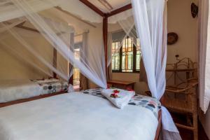 a bedroom with two beds with curtains and a window at Gorilla Valley Lodge in Bwindi Impenetrable Park