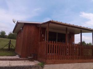 a wooden house with a fence in a field at eurl de l'écluse in Inor