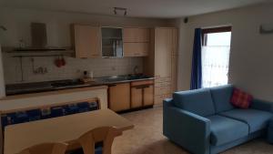 a living room with a blue couch and a kitchen at Casa Bedovina in Predazzo +25 photos