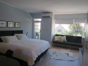 een slaapkamer met een groot bed en een raam bij Oranjehof Studios in Kaapstad