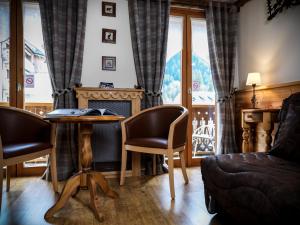 uma sala de estar com uma mesa e cadeiras e uma lareira em Auberge du Manoir em Chamonix-Mont-Blanc