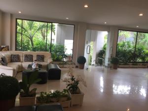 sala de estar con sofá y algunas plantas en Kyongean Mansion en Krabi