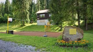 einen Park mit einem Gebäude und einem Basketballkorb in der Unterkunft Chaty Studienky in Oravský Biely Potok