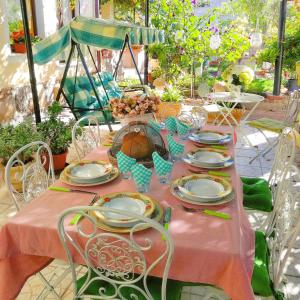 a table with a pink table cloth and plates on it at B&b il Giardino da Pina in Tuili