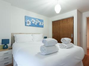 - une chambre avec un lit blanc et des serviettes dans l'établissement Castle Lanes, à Poole