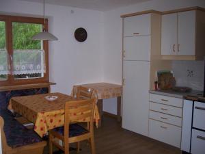 アンテルモイアにあるCiasa Honesのキッチン(小さなテーブル、白い冷蔵庫付)