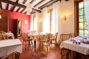 a dining room with tables and chairs and red walls at Résidence du Château de Bégué in Cazaubon