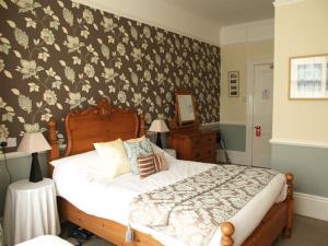 a bedroom with a bed with a floral wallpaper at Tower House 1066 in Hastings