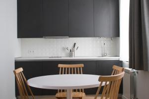 cocina con mesa blanca y sillas en Lux Apartamentos Rosalia en Santiago de Compostela