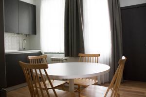 eine Küche mit einem weißen Tisch und Stühlen in der Unterkunft Lux Apartamentos Rosalia in Santiago de Compostela