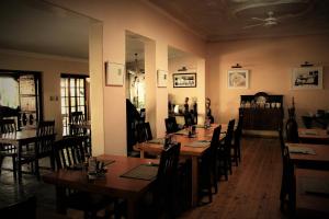 a restaurant with wooden tables and chairs in a room at African Roots Guest House in Polokwane