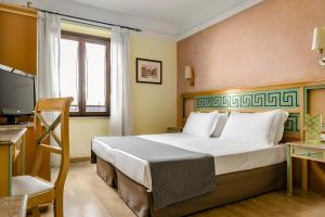 a hotel room with a bed and a television at Exe Domus Aurea in Rome