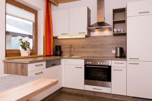 a kitchen with white cabinets and a sink at Ferienwohnung Eberharter Theresia in Ramsau im Zillertal