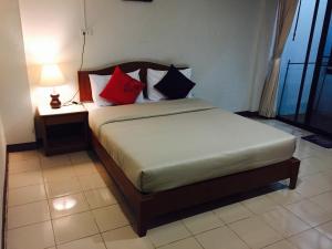 um quarto com uma cama com almofadas vermelhas e pretas em Kyongean Mansion em Krabi