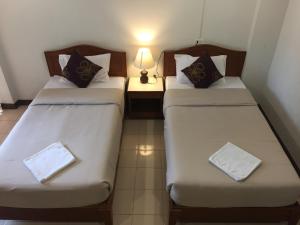 duas camas num quarto com um candeeiro sobre uma mesa em Kyongean Mansion em Krabi