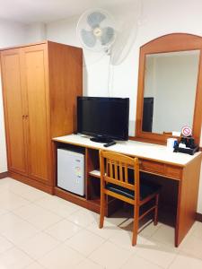 a room with a desk with a television and a mirror at Kyongean Mansion in Krabi