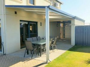 a patio with a table and chairs under awning at Palm Beach Manor in Rockingham