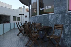 - une rangée de tables et de chaises en bois sur la terrasse dans l'établissement Hotel Oasis, à Santa Marta de Penaguião