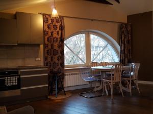 a kitchen with a table and chairs and a window at City Dawn Gate Apartment in Vilnius