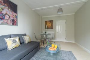 a living room with a couch and a table at Central Windsor Apartment Facing the Castle in Windsor