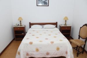 Hotel Oasis في سانتا مارتا دي بيناغياو: غرفة نوم بسرير وطاولتين وكرسي