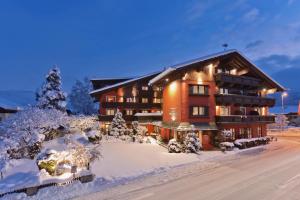 un lodge en la nieve con árboles nevados en Hotel Bruggwirt, en Sankt Johann in Tirol