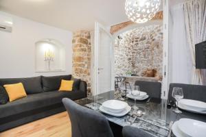 a living room with a couch and a table and chairs at Residence Teatro in Šibenik
