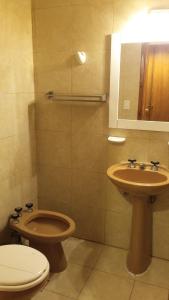 a bathroom with a toilet and a sink at Hotel Los Historicos in Villa Gesell