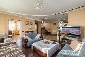 a living room with a large flat screen tv at Villa de Jardin in Svyatopetrivske