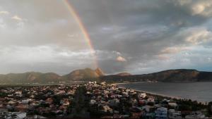 um arco-íris sobre uma cidade com uma praia e casas em Mirante Bela Vista em Niterói