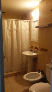 a bathroom with a sink and a toilet and a shower at Hotel Los Historicos in Villa Gesell