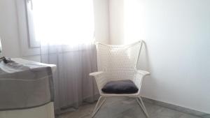 a white chair with a black cushion in a room at Manos Rooms in Mýkonos City